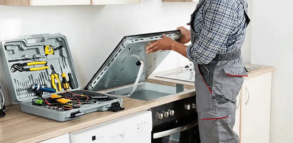 Handyman repairing a cooktop and checking wiring connections in Fort Lauderdale, FL
