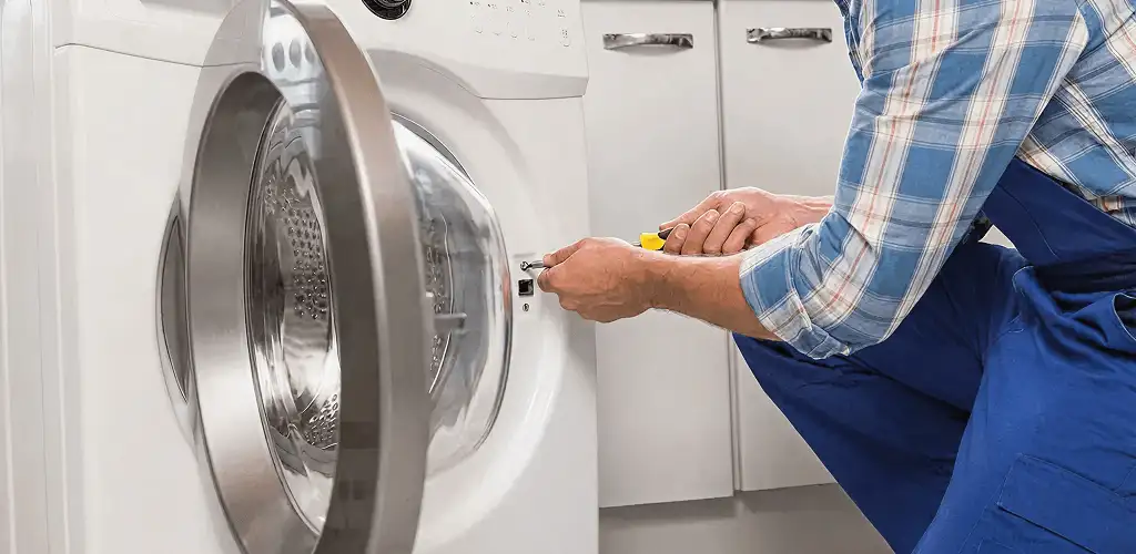 Handyman repairing a clothes dryer and checking electrical connections in Fort Lauderdale, FL