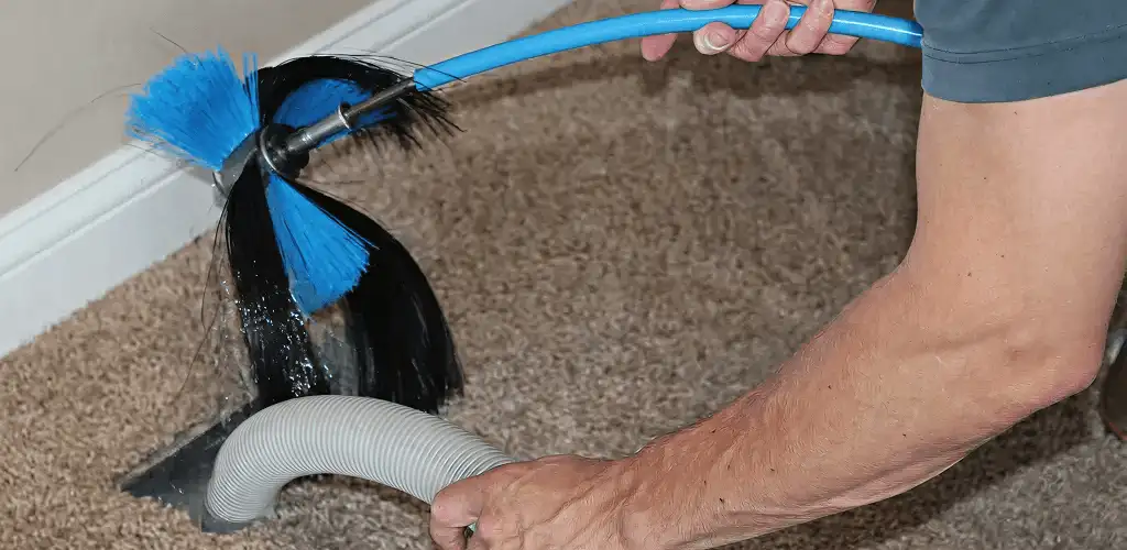 Dryer vent cleaning technician brushing lint from a vent line in Fort Lauderdale, FL