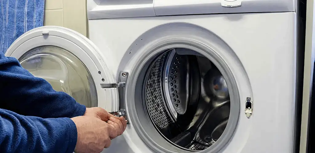 Washing machine repair handyman checking a front-load washer door and latch in Fort Lauderdale, FL