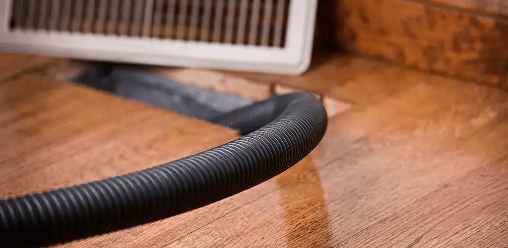 Air duct cleaning hose inserted into a floor vent for ductwork cleaning in Fort Lauderdale, FL