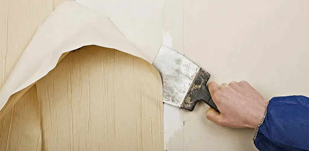 Handyman removing wallpaper with a scraper for wall preparation in Fort Lauderdale, FL