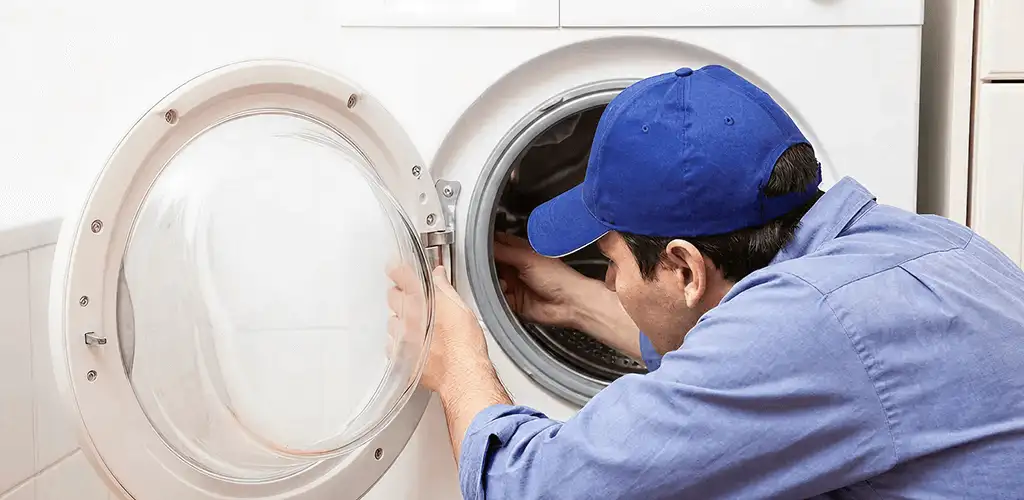 Washing machine repair handyman inspecting a front-load washer drum in Fort Lauderdale, FL