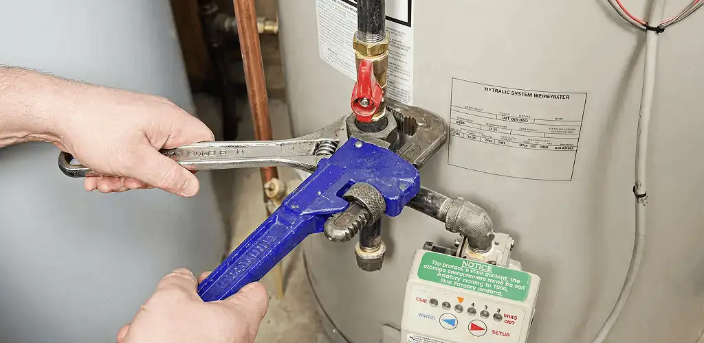 Water heater repair technician tightening the shutoff valve and supply line in Fort Lauderdale, FL